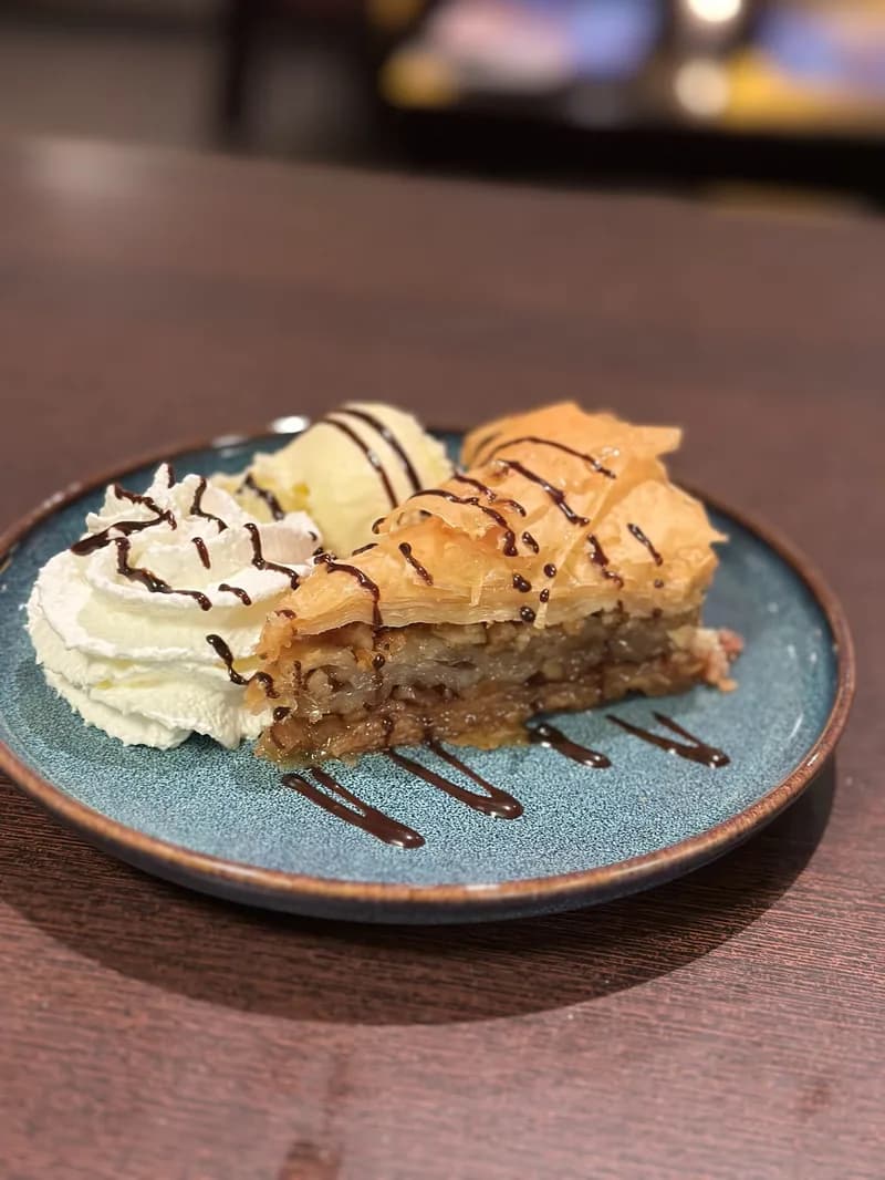 Baklava met slagroom, vanille-ijs en chocoladesaus
